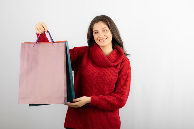 Foto di una signora felice che mostra le sue borse della spesa colorate.
