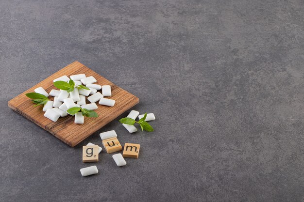 Foto grandangolare del mucchio di gomme bianche con foglie di menta sulla ciotola di legno