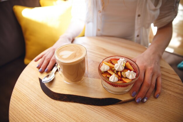 Foto potata della giovane signora della testarossa che si siede in caffè