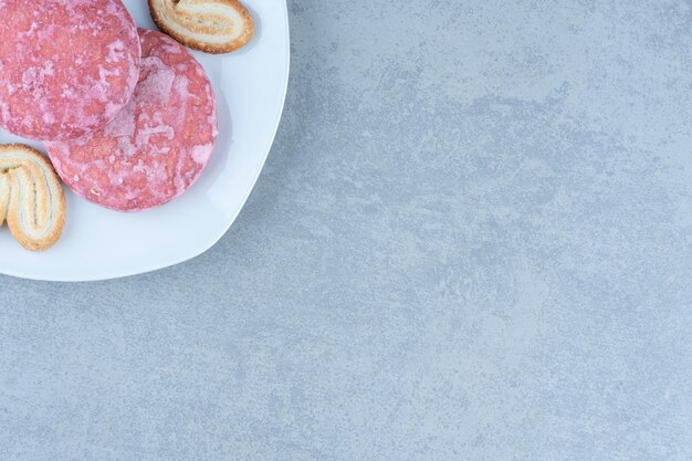 Foto ravvicinata di biscotti rosa su un piatto bianco