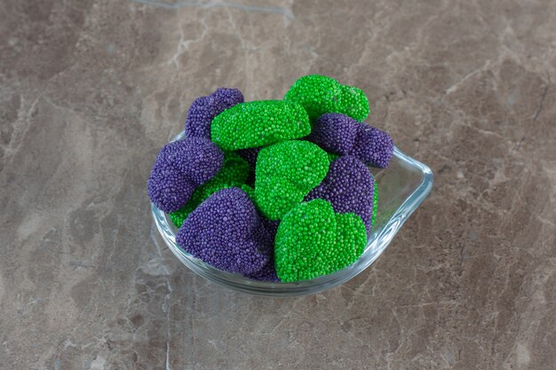 Foto ravvicinata di caramelle dolci verdi e viola a forma di cuore.