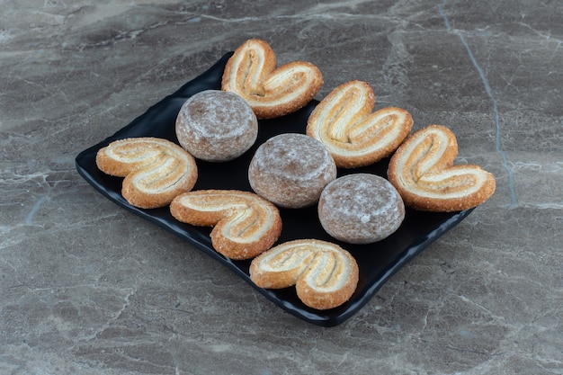 Foto ravvicinata di deliziosi biscotti freschi fatti in casa sulla banda nera.