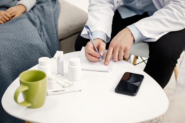 Foto ritagliata di un pediatra maschio che scrive una prescrizione per una ragazzina nera malata