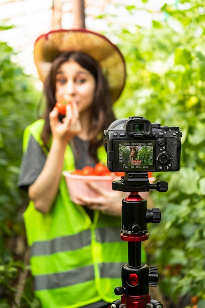 Foto verticale della giovane bella signora davanti a una macchina fotografica alla serra