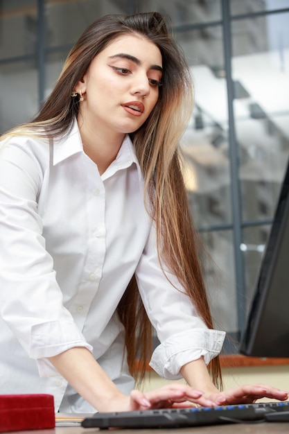 Foto verticale della ragazza che lavora al pc