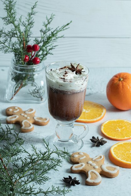 Foto verticale di gelato, biscotti e fette di arancia su bianco.