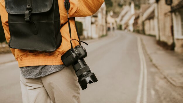 Fotocamera DSLR con tracolla appesa alla spalla del fotografo