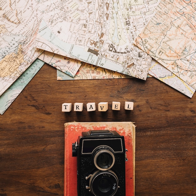 Fotocamera e libro vicino a scrittura e mappe