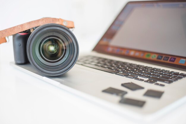Fotocamera professionale moderna e schede di memoria sul laptop