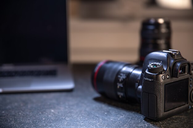 Fotocamera professionale su uno sfondo sfocato con un laptop