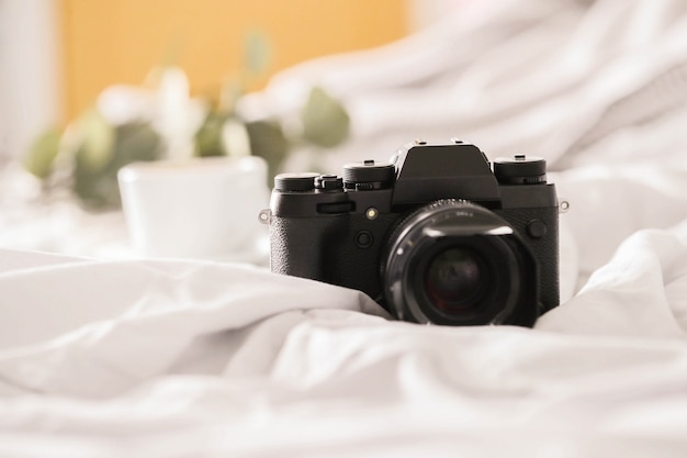 fotocamera sul letto e tazza di caffè