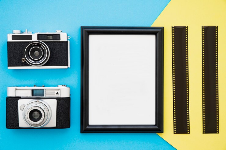 Foto gratuito fotocamere e film retrò vicino alla cornice