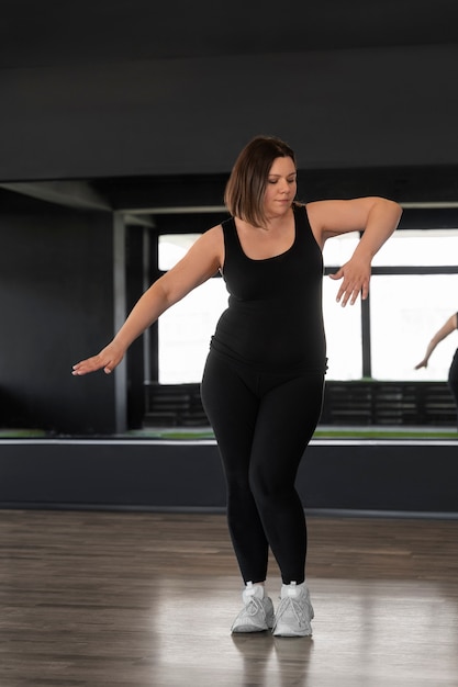 Fotografia completa di una donna che balla in studio