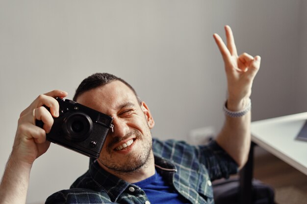 Fotografo che cattura maschera mentre osservando alla macchina fotografica