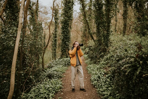 Fotografo che scatta foto nei boschi all'aperto