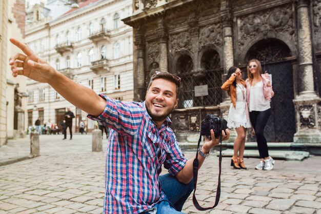 Fotografo di giovane uomo scattare foto, scattare foto con la fotocamera digitale ai suoi amici