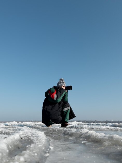 Fotografo donna che scatta foto della natura invernale