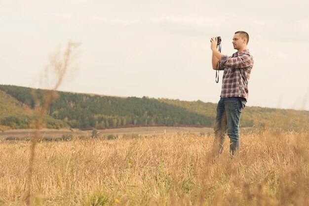 Fotografo maschio attraente all'aperto al tramonto