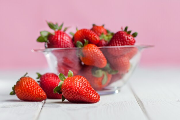 Fragola matura fresca in ciotola di vetro su legno