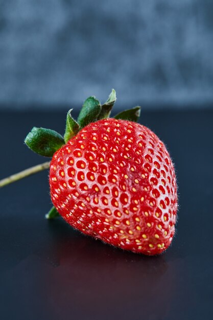 Fragola rossa fresca sulla superficie scura. Avvicinamento