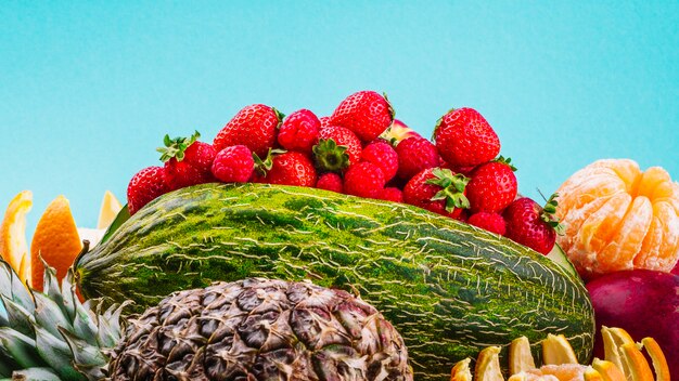 Fragole; arancia; ananas e anguria su sfondo blu