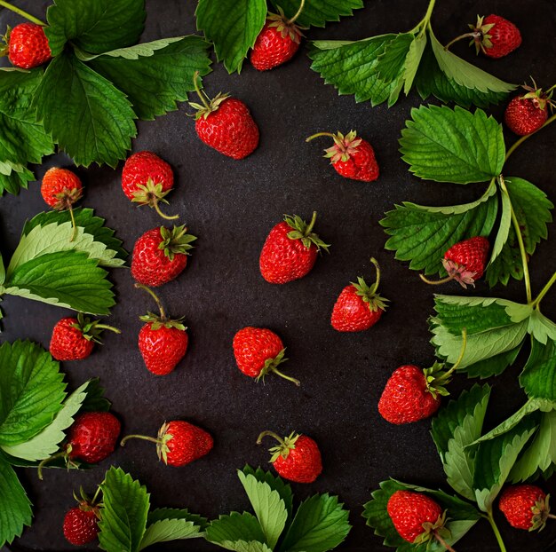 Fragole e foglie mature. Vista dall'alto