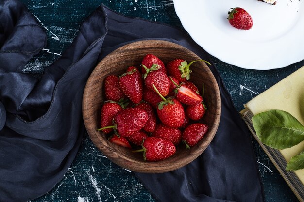 Fragole in una tazza di legno, vista dall'alto.