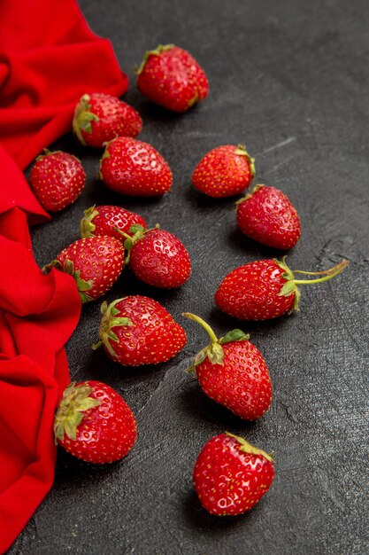 Fragole rosse fresche di vista frontale sui precedenti scuri