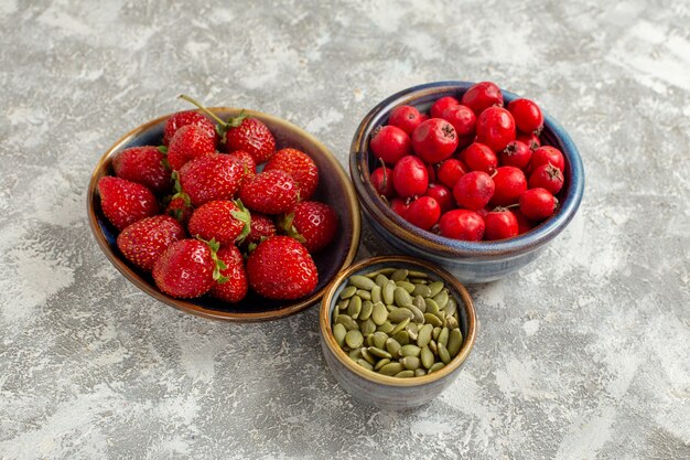 Fragole rosse fresche di vista frontale sulla bacca della frutta fresca di colore della pianta selvatica della tavola bianca