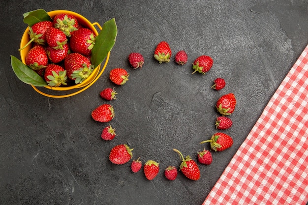 Fragole rosse fresche di vista superiore su un lampone scuro della frutta di colore della bacca della tavola