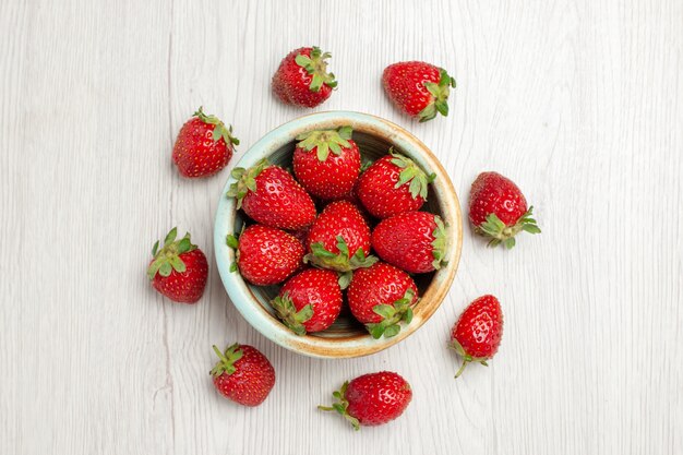 Fragole rosse fresche di vista superiore sullo scrittorio bianco