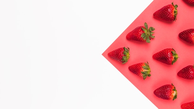 Fragole rosse gustose su sfondo multicolore rosa e bianco