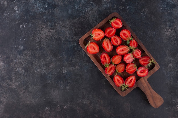 Fragole su una tavola di legno sul marmo grigio