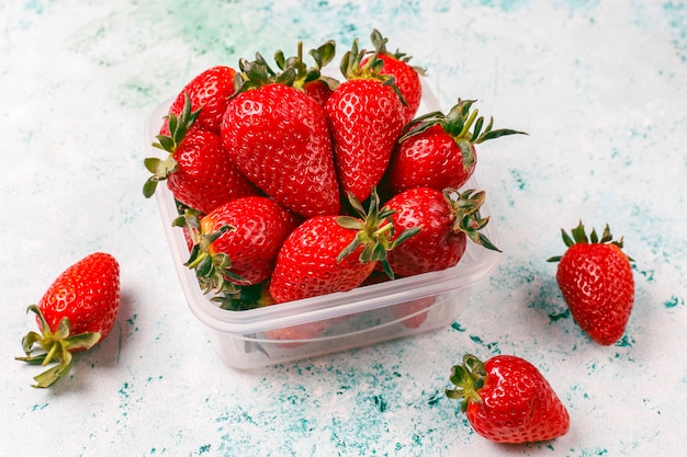 Fragole succose fresche in scatola di pranzo di plastica su luce