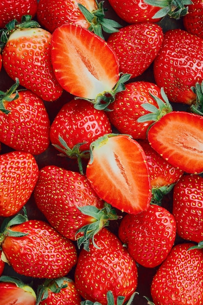 Fragole tagliate a metà e bacche intere bacche mature vista dall'alto Sfondo di fragole mature delizioso dessert naturale