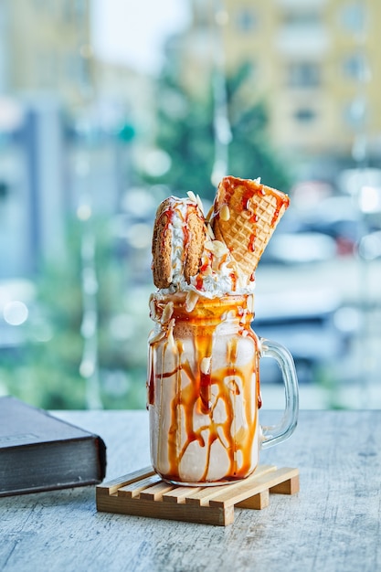 Frappè di anello di caramello sul piatto di legno con il libro.