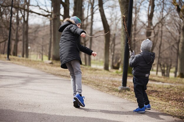 Fratelli che giocano con i bastoni nel parco