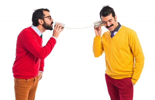 Fratelli gemelli che parlano con un telefono di stagno