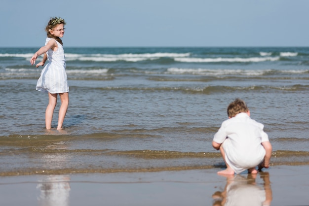 Fratello e sorella che godono di una spiaggia