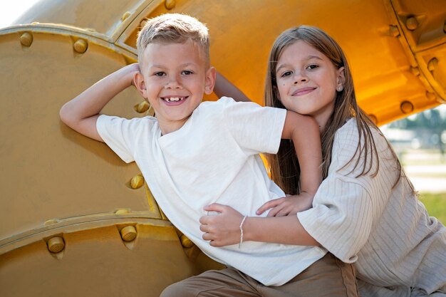 Fratello e sorella che si divertono nel parco giochi all'aperto