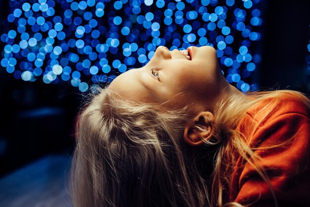 fratello e sorella sullo sfondo di una festosa ghirlanda, luci di Capodanno, bambini.