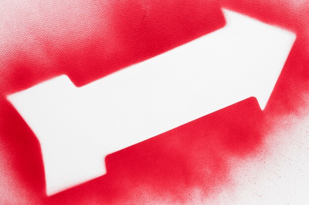Freccia bianca vista dall'alto con contorno rosso spruzzato