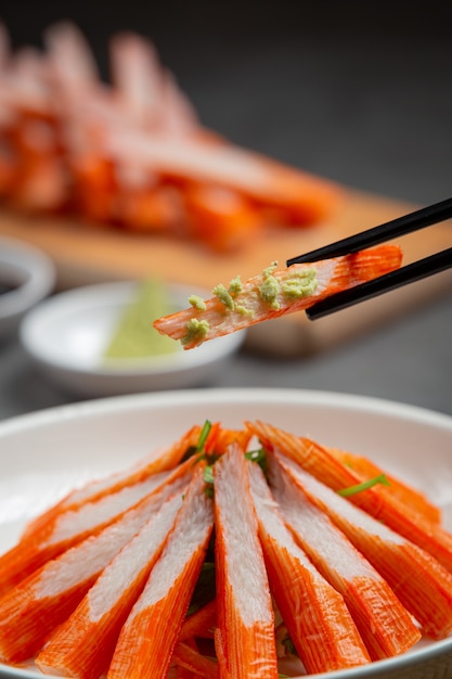 Fresche diapositive di bastoncini di granchio con wasabi e salsa di soia