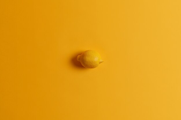 Fresco intero succulento succoso giallo limone in un unico colore con sfondo. Agrumi tropicali. Colpo monocromatico. Fonte di vitamine. Ingrediente per fare la limonata. Cibo sano, concetto di cibo
