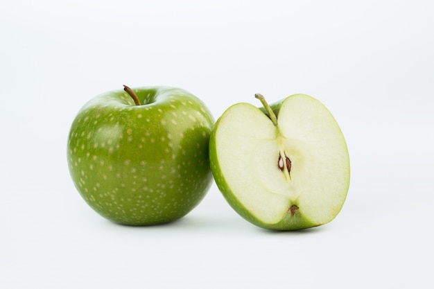 Fresco succoso dolce della mela verde isolato sul pavimento bianco