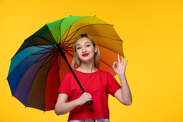 Frevo ragazza bionda carina che celebra il festival brasiliano con l'ombrello arcobaleno che mostra il gesto giusto