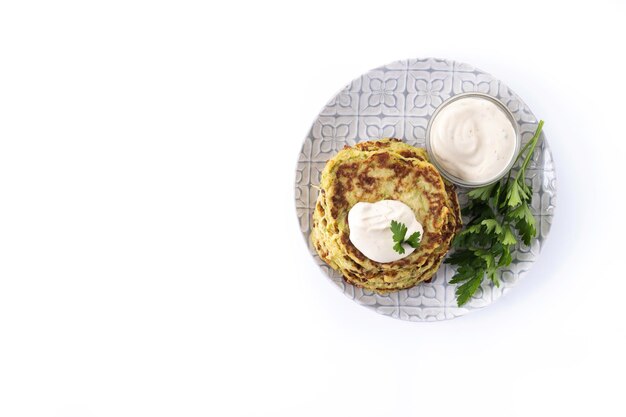 Frittelle di zucchine con salsa di yogurt isolate su sfondo bianco