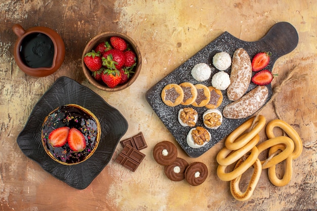 Frittelle dolci vista dall'alto con frutta e dolci sulla scrivania in legno