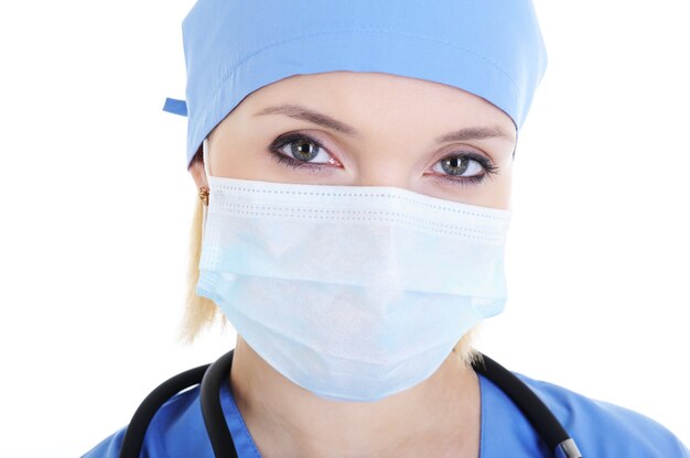 Fronte del primo piano del chirurgo femminile nella mascherina medica - isolato su bianco