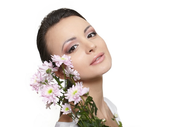 Fronte di bellezza di giovane bella donna con i fiori variopinti isolati su bianco